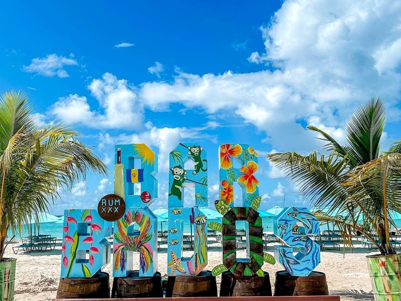 Пляж бухты Карлайл-Бей на Барбадосе с надписью Barbados и пальмами
